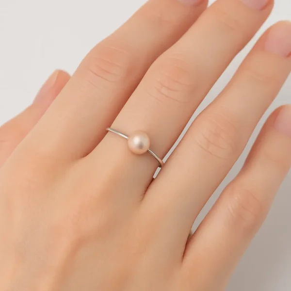 bague avec perle de culture blanche sur une main