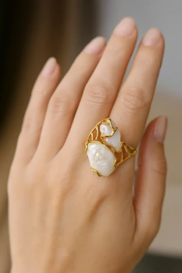 bague or perle de culture sur une main
